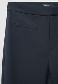 Pantalons noir marine en tissu tissé, avec un design élégant, un devant plat et une poche arrière unique avec des détails de couture minimale.
