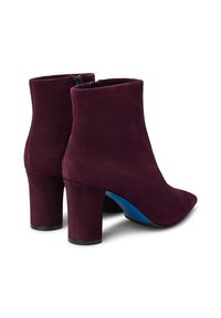Stivaletti alla caviglia in suede bordeaux con punta affusolata e tacco a blocco. Presentano un accento blu sul tacco e una chiusura con zip sul retro.