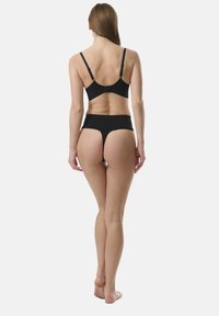 Svart behå och högbenta underkläder. Slät tyg, justerbara axelband, sömlös design, minimalistisk stil och krokupphängning.