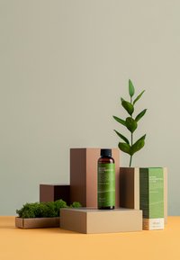 Bruna och beige lådor placerade på en gul yta visar en grön flaska med Benton Deep Green Tea Toner med svart kork och grön etikett.