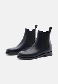 Botas Chelsea de cuero azul marino con paneles laterales elásticos, punta redonda y bucles para ponerlas fácilmente. Textura suave y suela de goma duradera.
