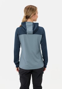 Giacca con cappuccio in tonalità di blu e grigio, caratterizzata da una combinazione di tessuti lisci e текстurizzati, con maniche lunghe e un design aderente.