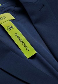 Marine stof met een gladde textuur, gekenmerkt door een felgroen label met de tekst "CIPOWERSTRETCH" en een grafisch logo.