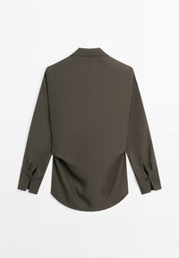 Blouse verte olive foncé à manches longues avec des poignets boutonnés, un col pointu et un ourlet légèrement courbé, vue de dos sur un fond blanc.