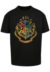 Black cotton t-shirt featuring a colorful Hogwarts crest design with a lion, eagle, badger, and serpent, framed by ornate gold accents.
