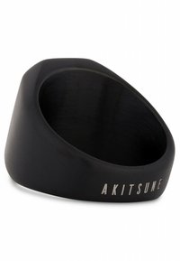 Black ring with a smooth, matte finish and a slightly rounded edge. Features engraved "AKITSUNE" text on the band. Geometric shape.