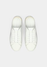 Pair of white Calvin Klein Jeans leather sneakers with laces, viewed from above on a plain white background.