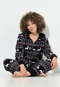 Monos de felpa negra con un patrón de renos y copos de nieve, con cierre delantero, capucha y puños acanalados. Presenta acentos en púrpura y blanco en el diseño.