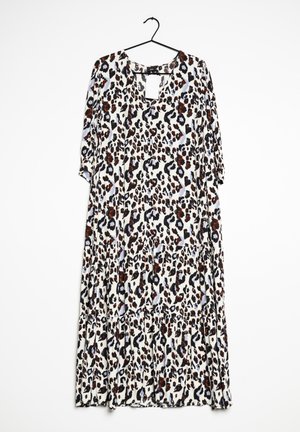 Longue robe ample avec manches trois-quarts et motif léopard marron, noir et blanc suspendue sur un cintre noir.