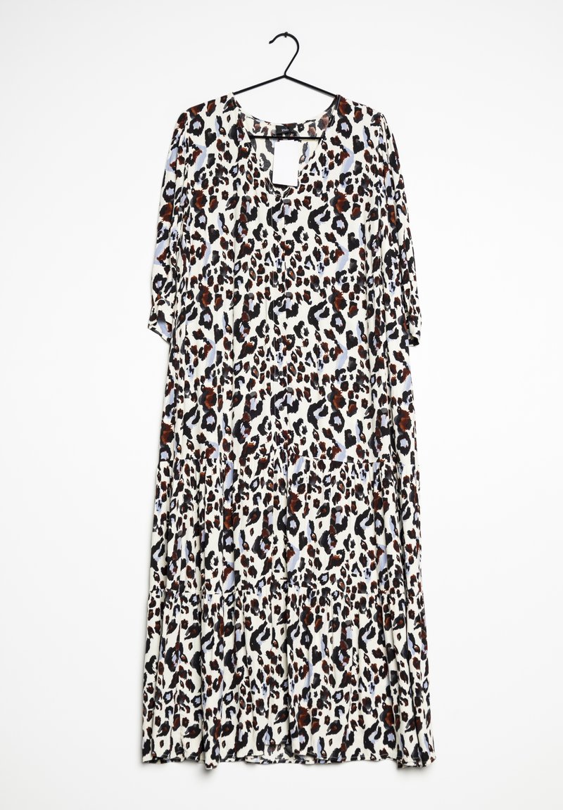 Longue robe ample avec manches trois-quarts et motif léopard marron, noir et blanc suspendue sur un cintre noir.