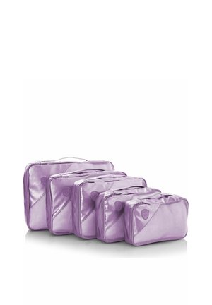 Ensemble de cinq cubes de rangement violets de tailles graduées, disposés côte à côte, avec fermetures éclair et poignées pour l'organisation de voyage.