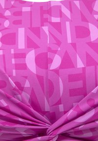 Rosa Stoff mit überlappenden Buchstaben in verschiedenen Rosatönen. Hat ein verdrehtes Design am unteren Rand und eine glatte Textur.