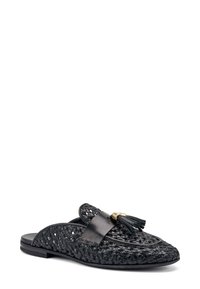 Scarpa nera intrecciata da infilare con una fascia in pelle liscia e dettaglio a nappina. Presenta una suola piatta e un design strutturato con una finitura testurizzata.