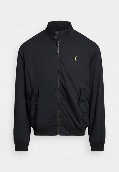 Chaqueta de nailon negra con un alto cuello, cremallera dorada, dos bolsillos laterales con solapas con botones y un pequeño logo bordado en el pecho.