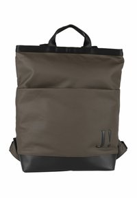 Brun tygryggsäck med en strukturerad yta, svarta accenter vid basen, ett handtag ovanpå och justerbara axelremmar. Har en präglad logotyp "J!".