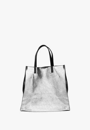 Sac fourre-tout en métal argenté avec des poignées en cuir noir. Le sac présente une texture lisse et un design minimaliste sans embellissements supplémentaires.