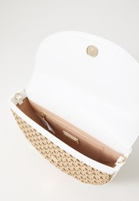 Vävd beige handväska med en vit läderklaff, guldfärgad knappstängning och ett mjukt beige inre med en dragkedjeförsedd ficka och kortfack.