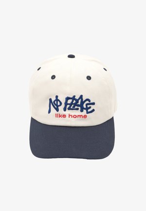 Casquette de baseball blanche avec visière marine, affichant le texte brodé "Pas d'endroit comme chez soi" en bleu et rouge. Matériau en coton, design à six panneaux.