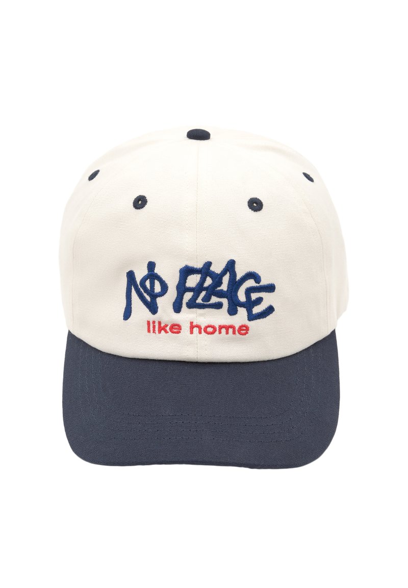 Casquette de baseball blanche avec visière marine, affichant le texte brodé "Pas d'endroit comme chez soi" en bleu et rouge. Matériau en coton, design à six panneaux.