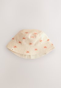 Chapeau bob crème en tissu texturé avec des imprimés de soleils orange éparpillés et une petite étiquette logo. Matière douce et légère.