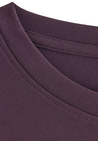 Fialový textil zblízka s kulatým výstřihem. Má hladkou texturu a viditelné švy podél límce a okrajů textilie.