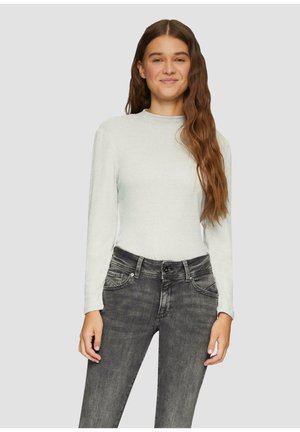 Lichtgrijze geribbelde langemouwen top, gecombineerd met donkergrijze denim jeans met frontzakken en een knoopsluiting.