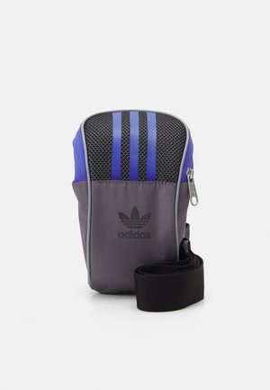 Borsa a spalla Adidas in grigio e blu. Presenta pannelli in rete, tre strisce verticali, un logo e una tracolla nera rimovibile. Chiusura con zip.