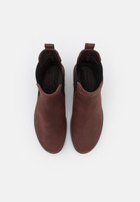 Bottines en cuir marron avec une finition lisse, des panneaux latéraux élastiques et des tirants pour un enfilage facile. Semelles en caoutchouc plates pour la stabilité.