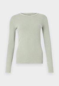 Dlouhá rukáv, žebrovaný pletený top v světle šalvějové barvě s kulatým výstřihem, přiléhavým střihem a jednoduchým designem na bílém pozadí.