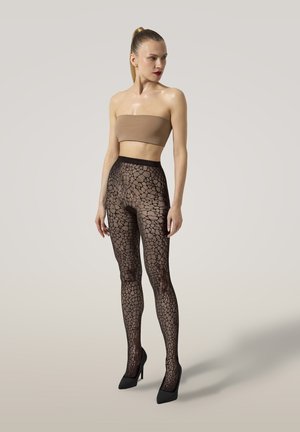 Leggings neri in pizzo con un motivo geometrico, vita alta e una texture liscia e trasparente, abbinati a un top nudo senza spalline e tacchi neri.