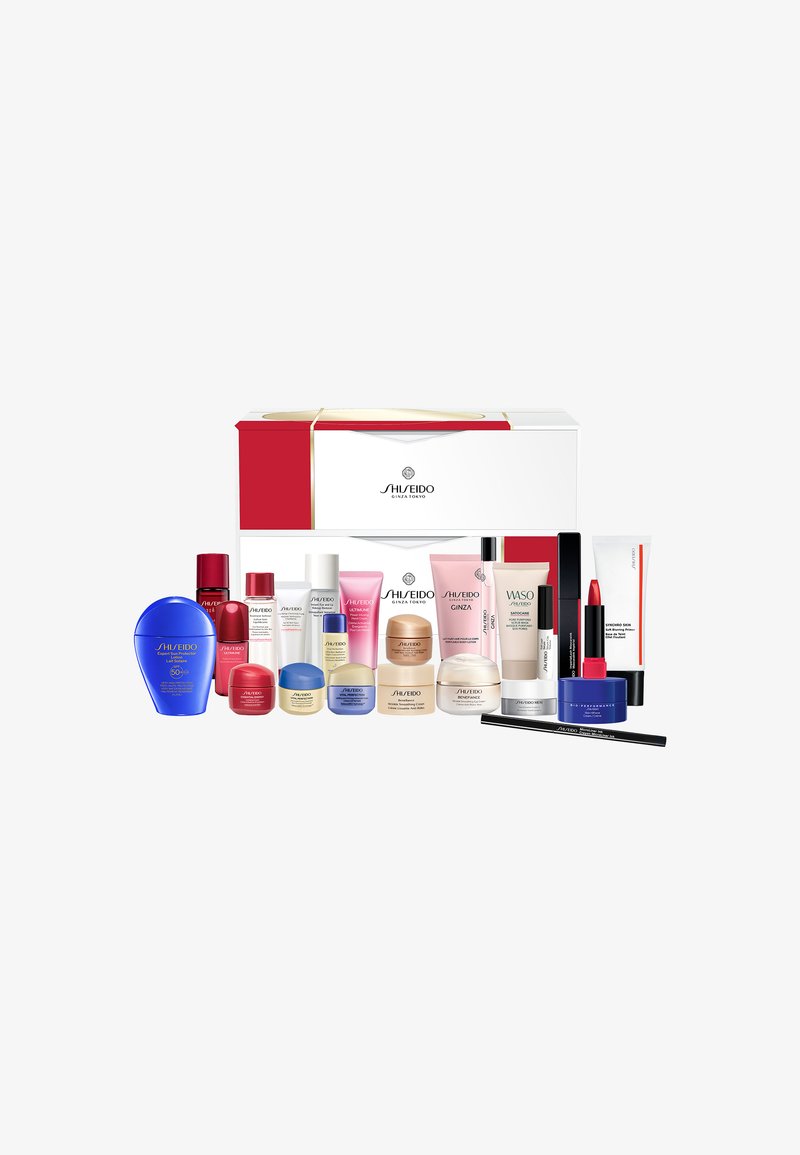 Shiseido gift set in a white box with red accents and gold ribbon, featuring multiple skincare and makeup products in various sizes and colors.