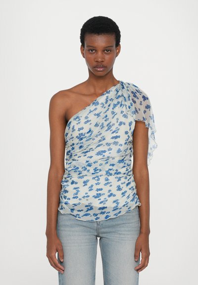 Blusa de un solo hombro en tela translúcida de color azul claro, con un patrón floral en azul oscuro. Fruncido en la cintura y una manga fluida.