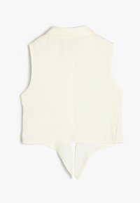 Ärmellose crèmefarbene Bluse mit Kragen, mit abgerundetem Saum und einem Schlitz hinten. Hergestellt aus glattem Stoff mit minimalen Nähten.