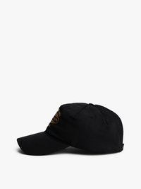 Svart caps med buet skjerm, med et gullbrodert logo foran. Laget av glatt stoff, med sømdetaljer og ventilasjonsårer.