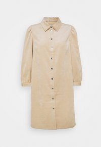 Robe beige mi-longue avec manches longues bouffantes, fermeture boutonnée à l'avant et col pointu sur fond blanc.