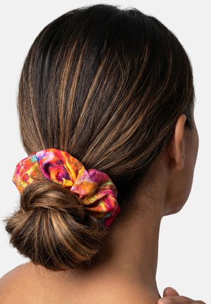 Ciemnobrązowe włosy kobiety związane w niski kok, zabezpieczone kolorową, wielobarwną gumką do włosów.