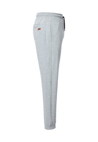 Graue Sweatpants mit einem elastischen Bund, Seitentaschen und einem kleinen braunen Etikett. Der Stoff wirkt glatt und hat eine weiche Textur.