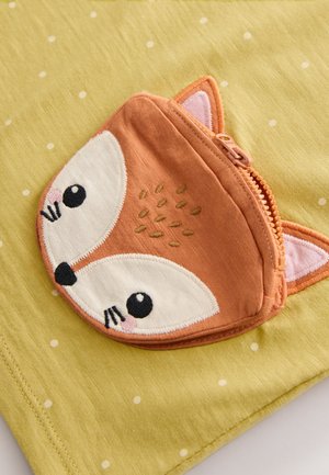 Grønt stof med hvide polkaprikker har en lynlåslomme formet som en orange ræv med broderede ansigtsdetaljer, herunder øjne og ører.