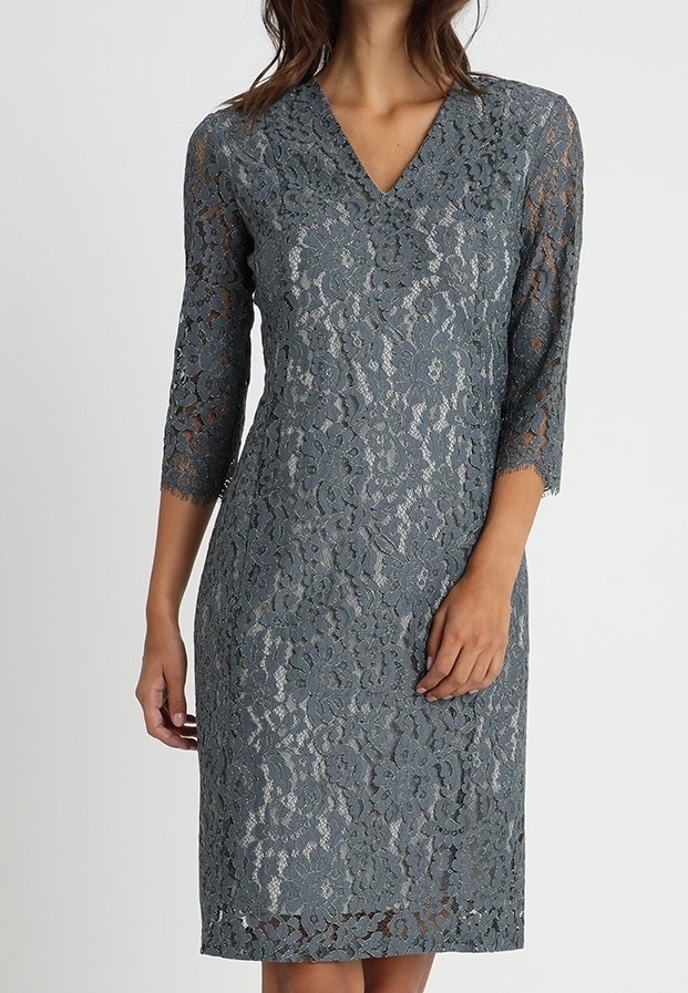 Une robe en dentelle grise jusqu'aux genoux avec des manches trois-quarts, un décolleté en V et des motifs floraux. Le tissu est transparent avec une finition texturée.