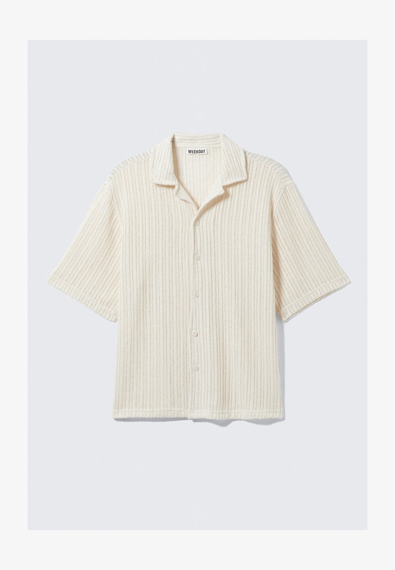 Chemise à manches courtes, boutonnée, couleur crème, avec une texture côtelée verticale et un col classique. Tissu doux avec des détails de motif subtils.