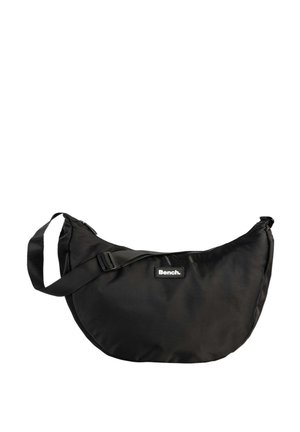 Zwarte nylon schoudertas met een gebogen vorm, verstelbare schouderband en een opvallend logopatch. Gladde textuur met een ritsluiting.