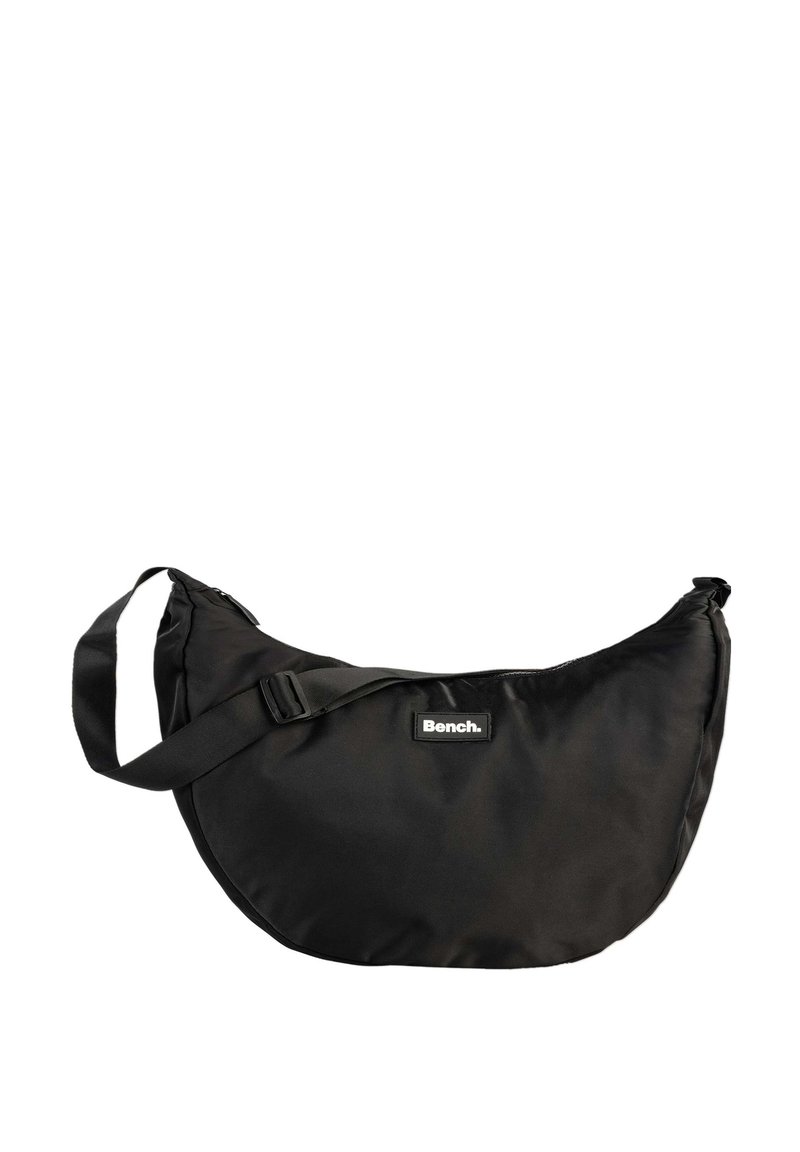 Zwarte nylon schoudertas met een gebogen vorm, een verstelbare schouderband en een rechthoekig logo-opdruk met de merknaam "Bench."