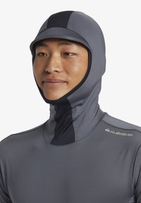 Grå neoprenhuvud med integrerad keps, slät textur, åtsittande design, har svarta accenter, Quiksilver-logotyp på axeln.