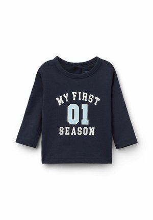 Marineblaue Langarmshirt aus Baumwolle, mit weißem und hellblauem Text: "MEINE ERSTE 01 SAISON." Rundhalsausschnitt und gerader Saum, ohne sichtbare Verschlüsse.