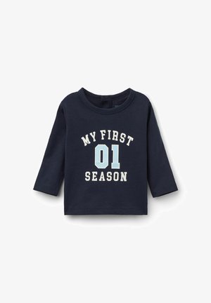 Chemise à manches longues en coton navy, ornée de texte blanc et bleu clair : "MA PREMIÈRE SAISON 01." Encolure ronde et ourlet droit, sans fermetures visibles.
