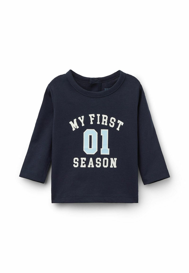Námořnické tričko s dlouhým rukávem ze 100% bavlny, na kterém je bílé a světle modré písmo: "MOJE PRVNÍ 01 SEZÓNA." Kulatý výstřih a rovný lem, bez viditelných zapínání.