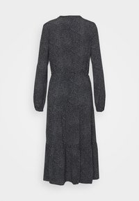 Schwarzes Kleid mit langen Ärmeln, strukturierter Stoff mit kleinen weißen Punkten, tailliert und mit einem ausgestellten Rock, der unter das Knie reicht.