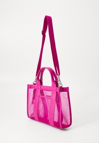 Rosa mesh-väska med fasta rosa remmar och detaljer. Utrustad med två handtag och en justerbar axelrem. Fickan i fram.