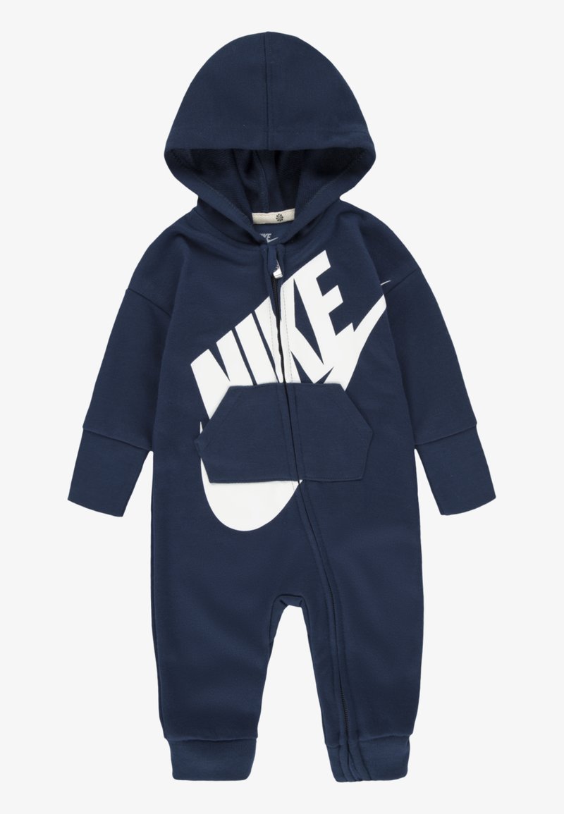 Tengerészkék kapucnis overál puha anyagból, fehér Nike logóval, elülső zsebbel és teljes hosszúságú cipzárral.
