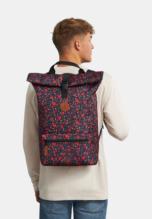 Floral-patterned backpack with a blue background, red and pink flowers, roll-top design, adjustable straps, and a front zip pocket.